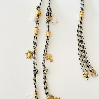 Colar com fios trançados e pendentes dourados em fundo branco