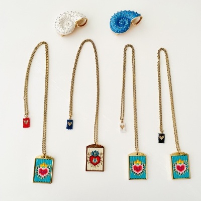 Colares dourados com pendentes de coração vermelho e conchas decorativas branca e azul
