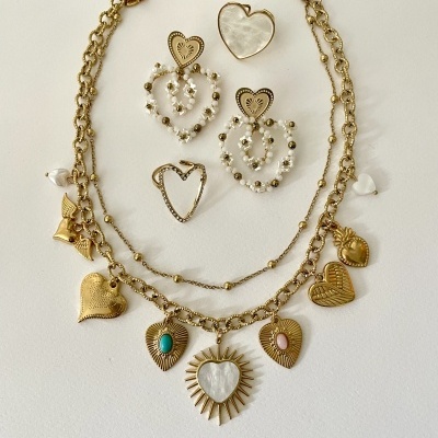 Conjunto de bijuteria dourada com corações em vários estilos sobre fundo branco