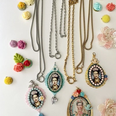 Colares com pendentes decorados com imagens de Frida Kahlo rodeados de flores coloridas em fundo branco.