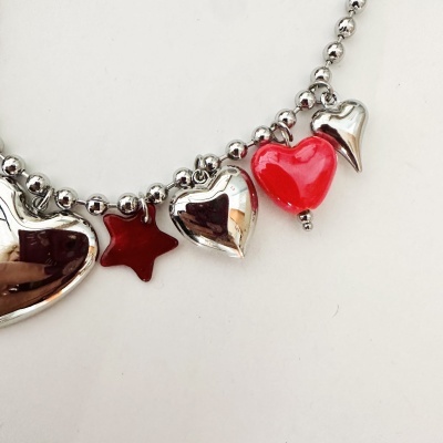 Pulseira com pendentes em forma de corações e estrela nas cores vermelho e prateado