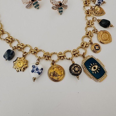 Colar dourado com pendentes diversos em azul, branco e preto