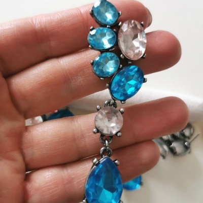 Brinco com pedras azuis e transparentes em metal prateado