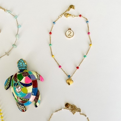 Pulseiras e pendente coloridos sobre fundo branco.