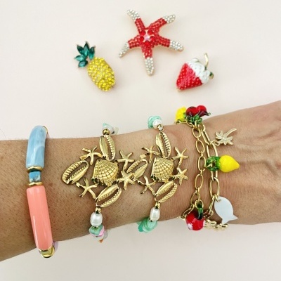Pulseras com pendentes de frutas e elementos marinhos no pulso