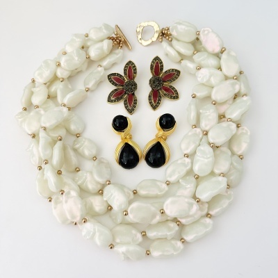 Colar de pérolas brancas e dois pares de brincos coloridos em fundo branco