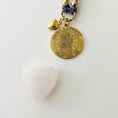 Colar com pendente dourado de Saint Raphael e cordão azul, com coração de pedra branca ao lado