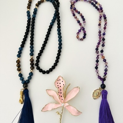 Dois colares coloridos com pendentes tassel e flor cor-de-rosa decorativa no centro