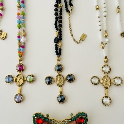 Colares com crucifixos dourados e pedras coloridas com broche de borboleta decorado