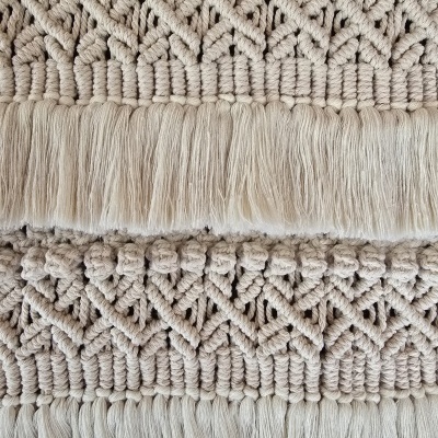 Têxtil macramê bege com padrão geométrico e franjas
