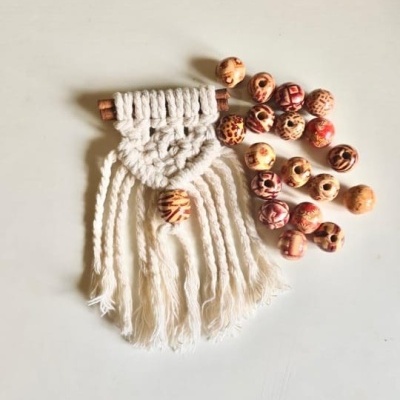 Pendurar decorativo em macramé branco com contas de madeira rosa e vermelha