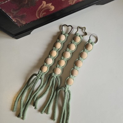 Três porta-chaves de corda verde e contas de madeira clara com franjas e argolas metálicas