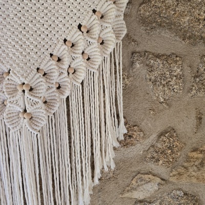Decoração de parede em macramé branco com contas de madeira