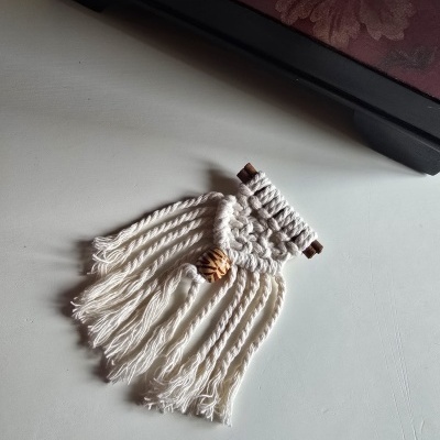Objeto decorativo em macramé branco com franja e conta de madeira