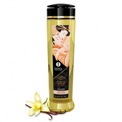 Frasco amarelo translúcido de óleo de massagem com tampa preta e etiqueta ilustrada, com flor de baunilha ao lado.