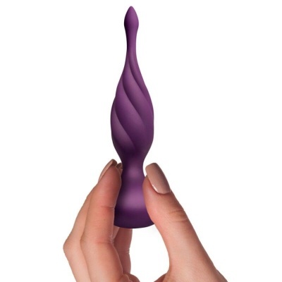 Plug anal roxo com textura espiral segurado por uma mão