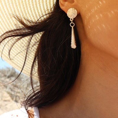 Brinco pendente dourado com base circular martelada e detalhe branco