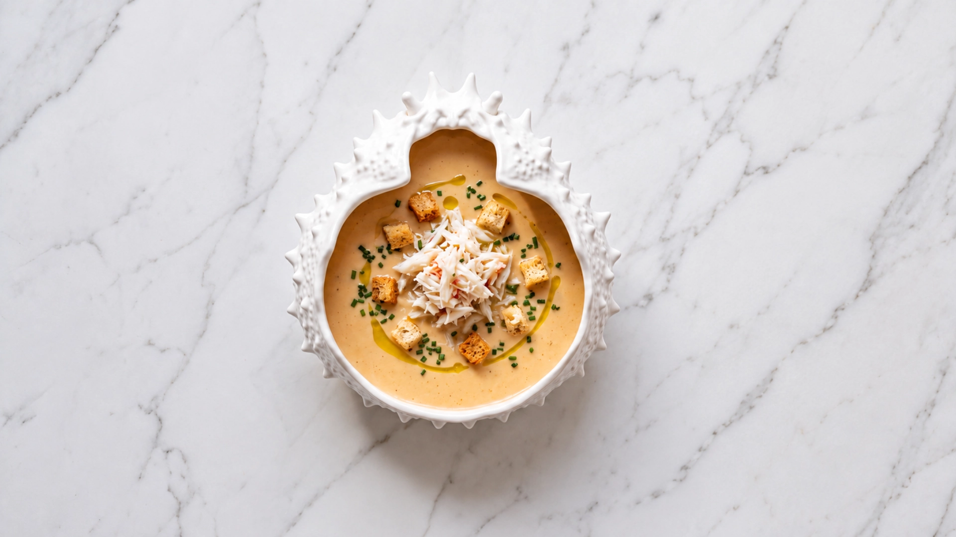 CREME DE SANTOLA sopa cremosa numa tigela branca com concha decorativa, com pedaços de pão e ervas