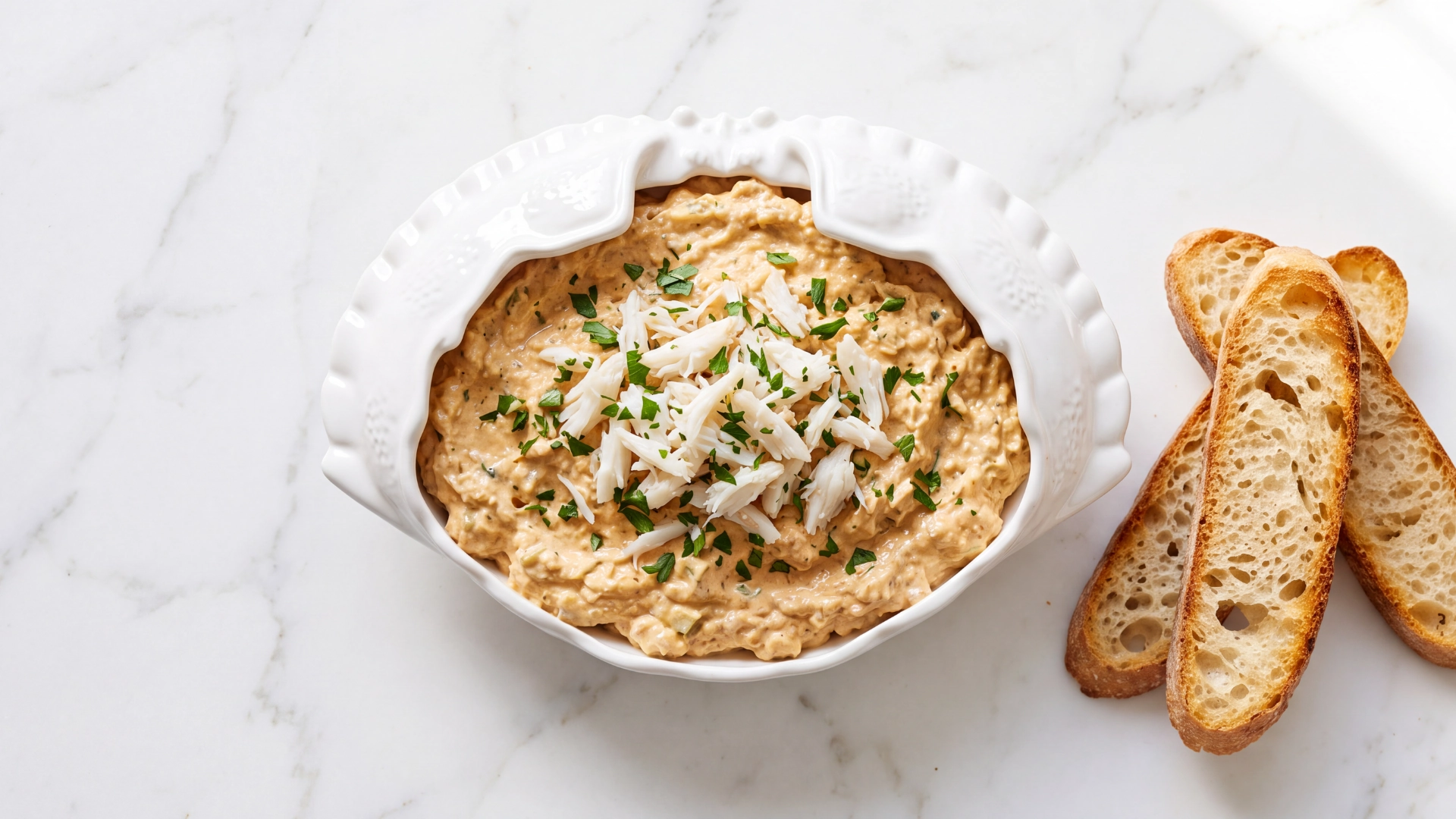 RECHEIO DE SAPATEIRA Tigela branca com creme de pasta e pedaços de peixe, fatias de pão torrado ao lado