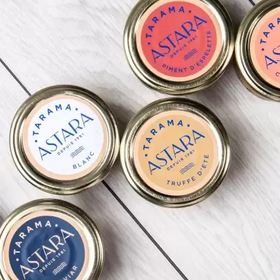 Latas de conserva ASTARA coloridas sobre superfície de madeira clara
