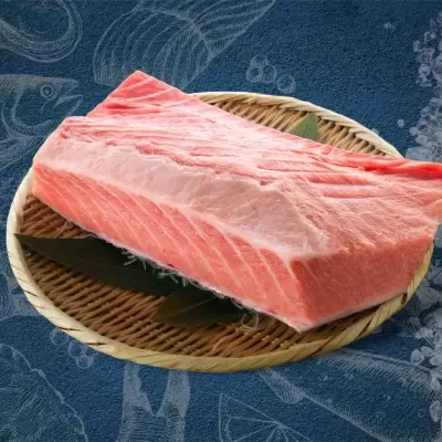 Pedaço de salmão cru em prato de verga com folhas verdes e gelo ao lado