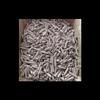 Buchas de expansão de plástico cinza empilhadas num recipiente de tecido bege