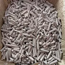 Buchas de expansão de plástico cinza empilhadas num recipiente de tecido bege
