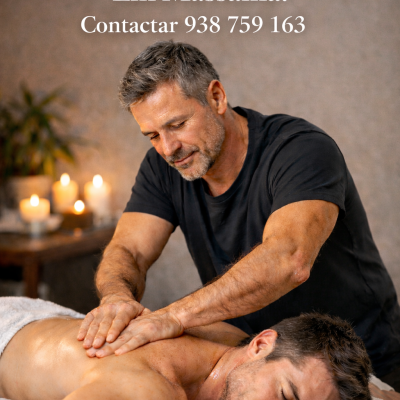 Massagista masculino a fazer massagem nas costas de um homem deitado numa mesa de massagem com velas ao fundo