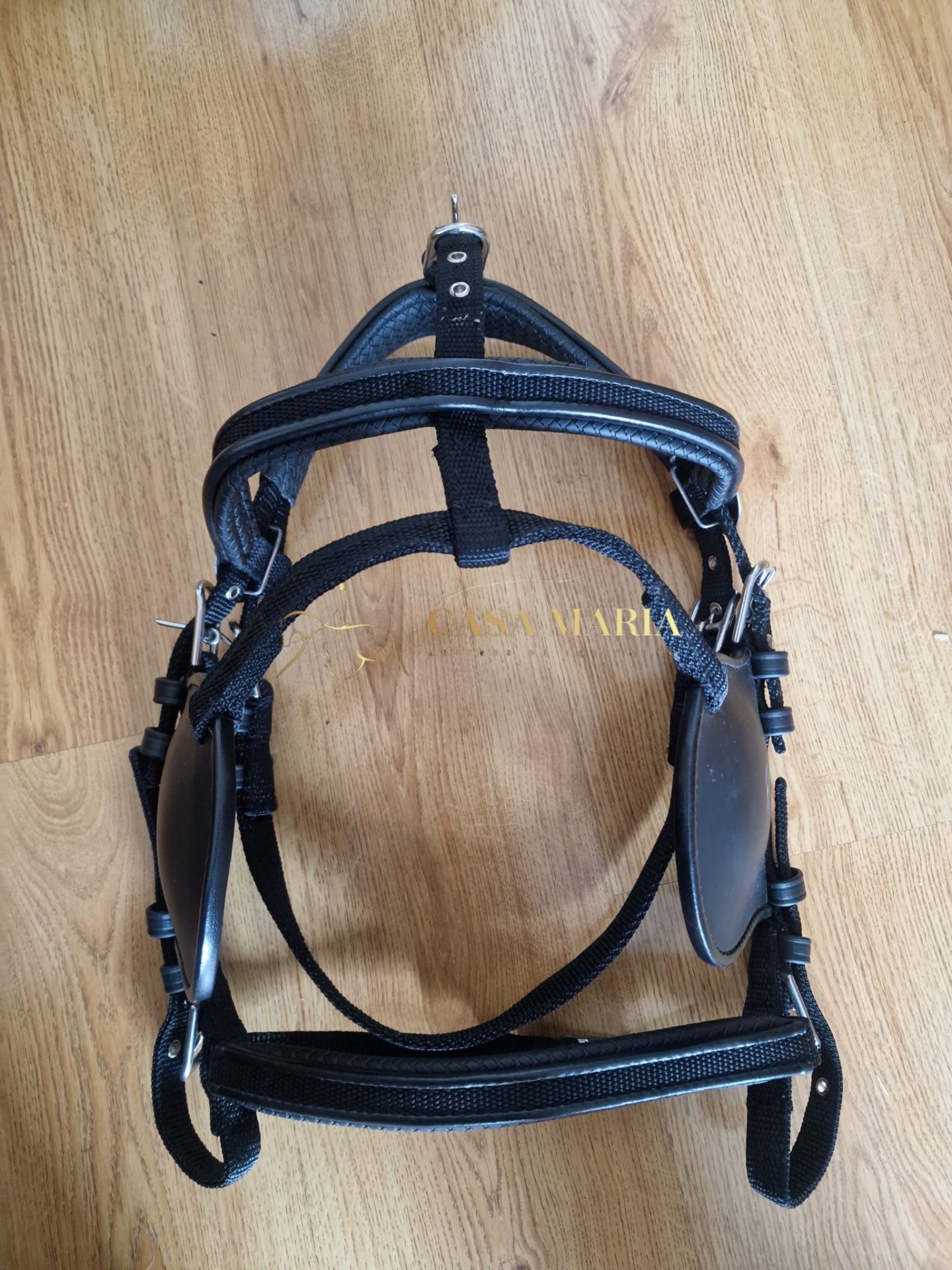 Cabresto de nylon preto com detalhes em couro sobre chão de madeira