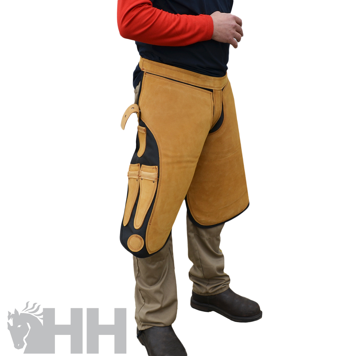 Calças ou perneiras de proteção castanhas e pretas usadas sobre calças bege