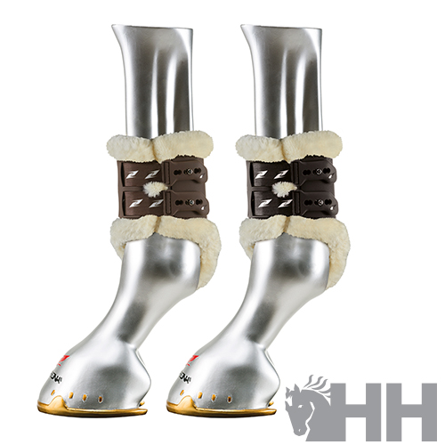 Par de botas para cavalo em couro castanho com pêlo sintético bege num manequim prateado