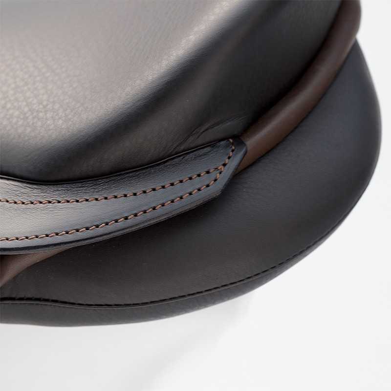Detalhe de assento em couro preto com costura castanha