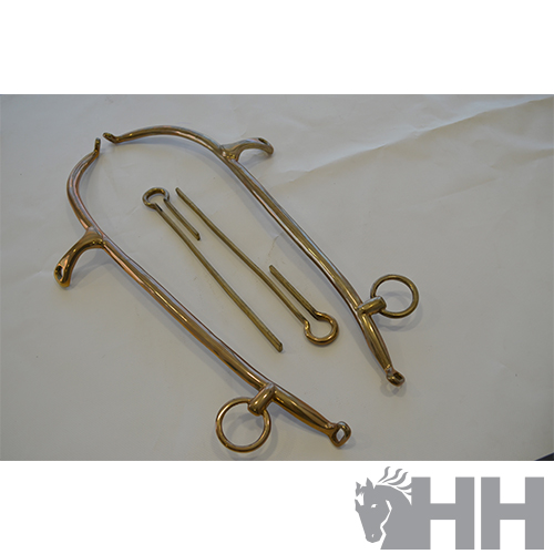 Espora de metal prateado e pinos sobre superfície branca