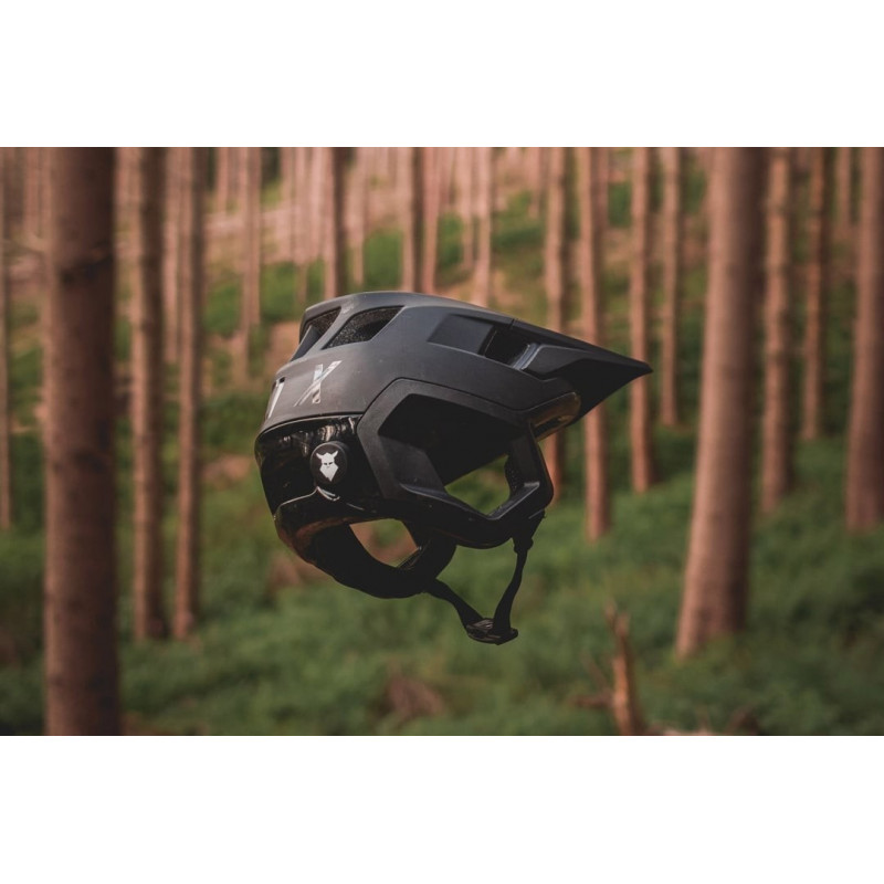 Capacete preto de ciclismo suspenso em floresta