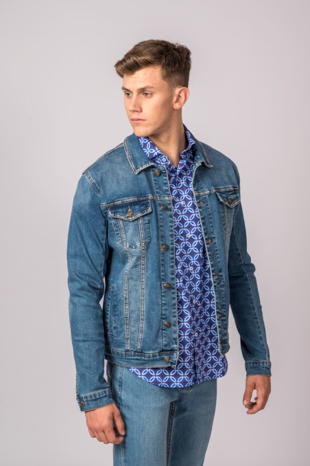 Homem com casaco de ganga azul e camisa azul estampada