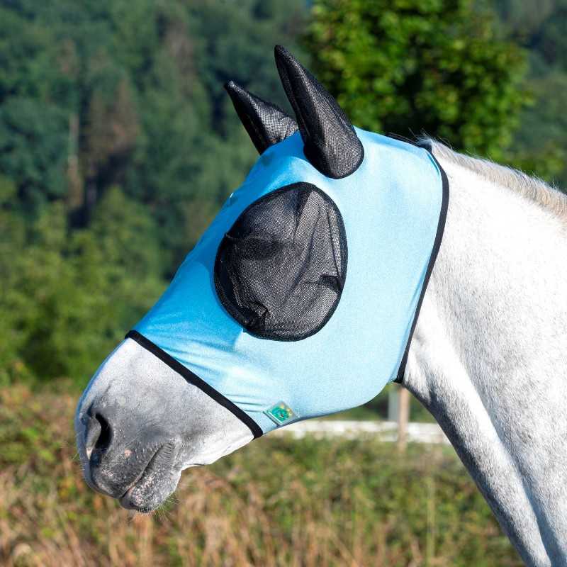 Máscara azul clara com detalhes em preto a cobrir cabeça de cavalo branco ao ar livre