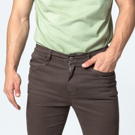 Homem com calças castanhas e camiseta verde claro
