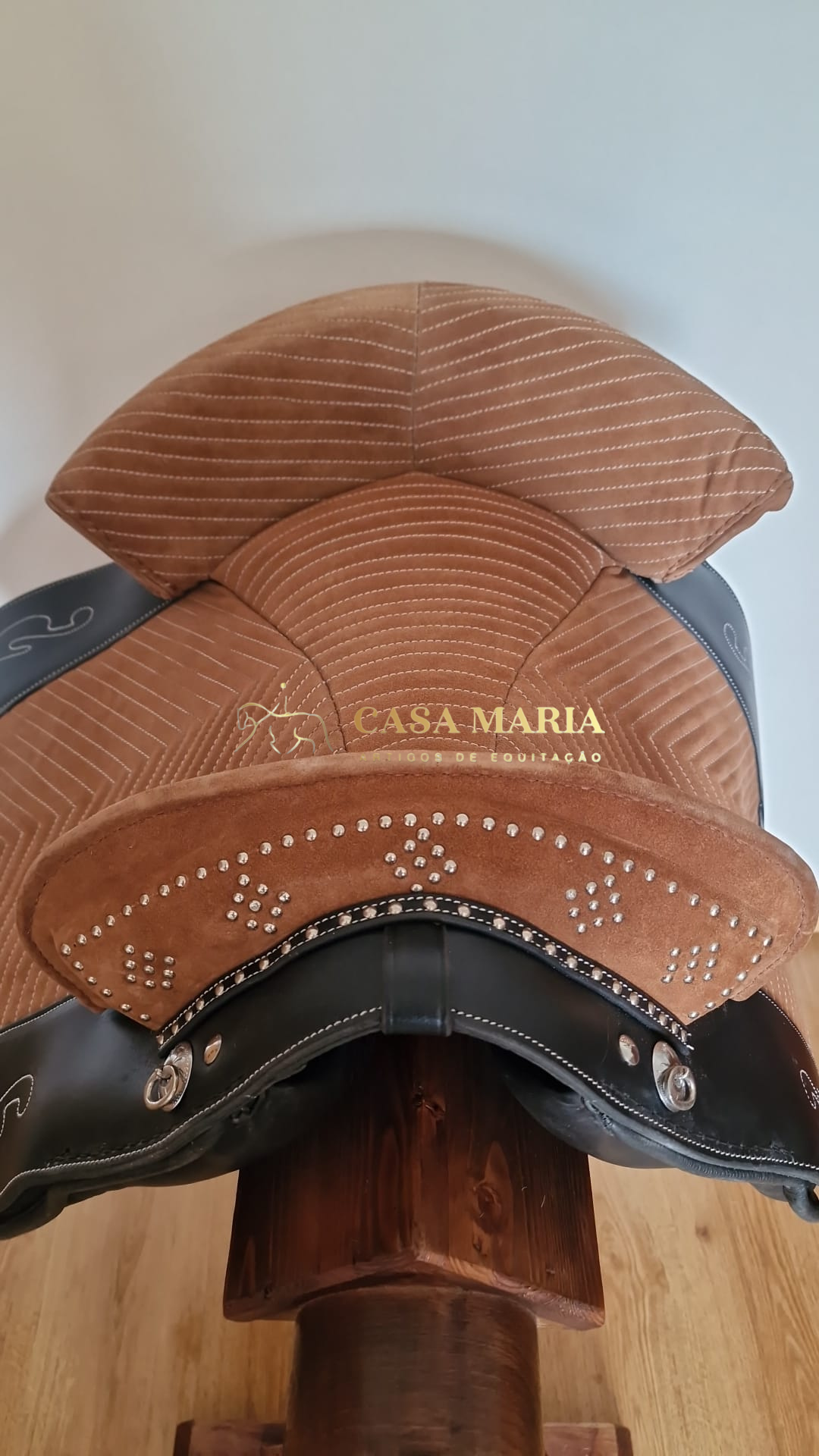 Sela de equitação castanha e preta com texto CASA MARIA