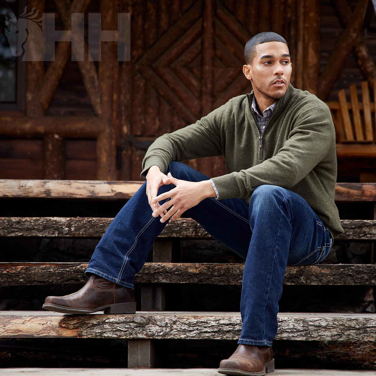 Homem com roupas casuais sentado em escadaria de madeira rústica