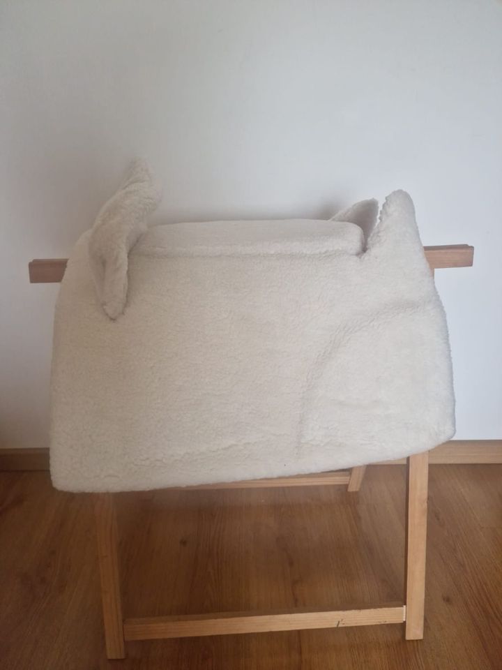 Manta branca peluda sobre estrutura de madeira