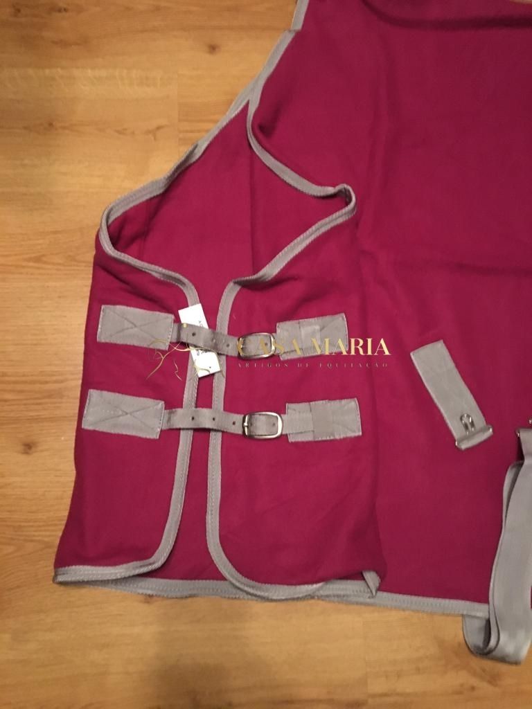 Manta vermelha com bordas cinzentas, fivelas e texto dourado