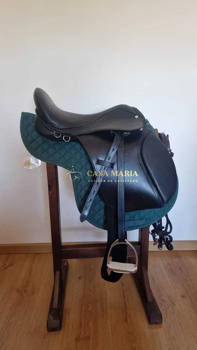 Sela de equitação preta com almofada verde em suporte de madeira