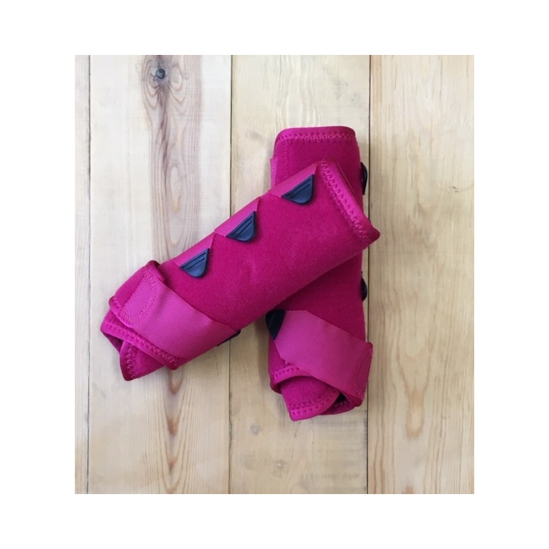 Par de proteções rosadas sobre chão de madeira clara