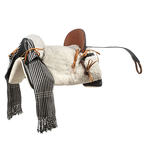 Sela de cavalo tradicional com assento castanho e mantas riscas pretas e brancas