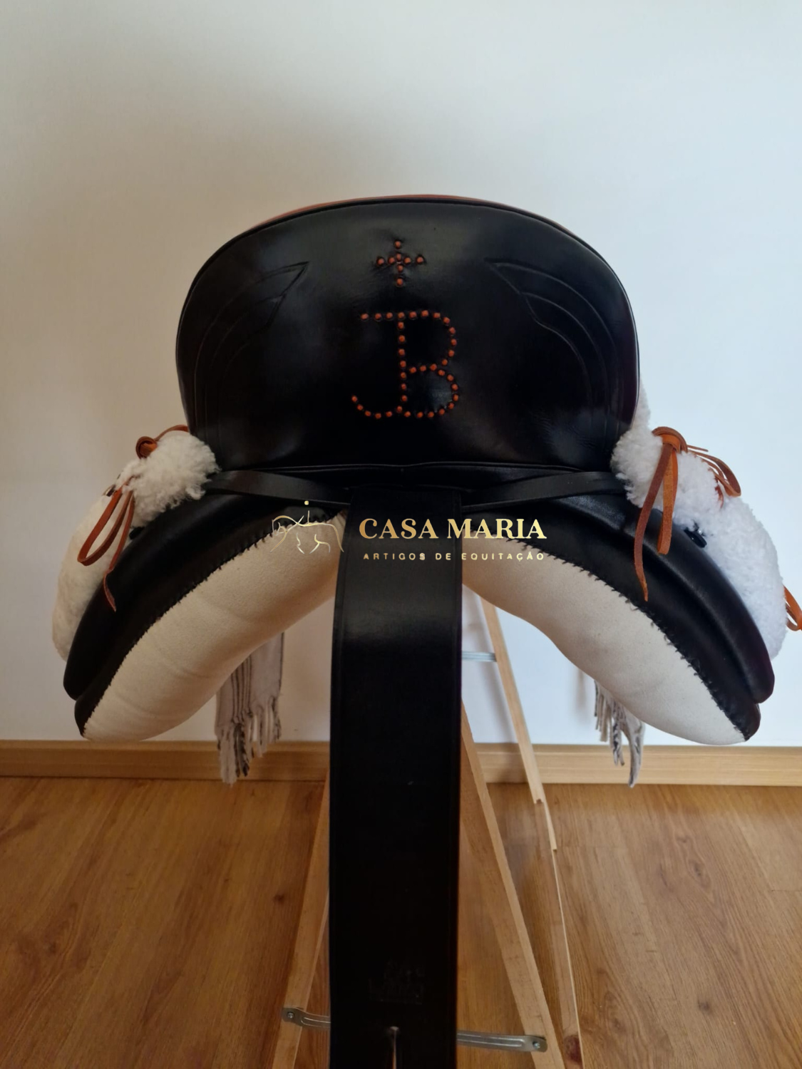 Sela preta com almofadas brancas e monograma JB