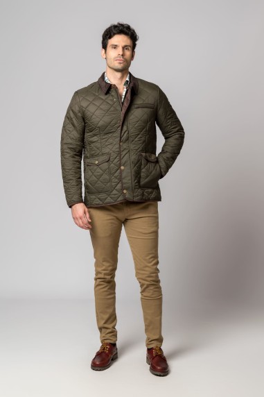 Homem com casaco acolchoado verde-oliva, calças bege e botas castanhas