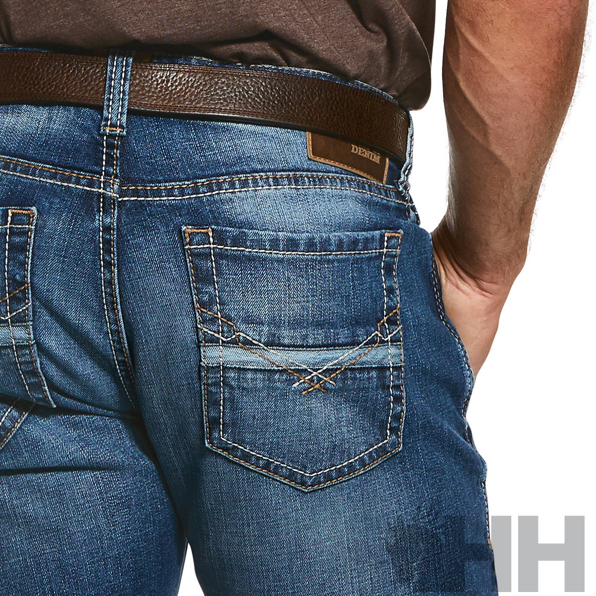 Calças de ganga azuis com cinto castanho e bolso traseiro detalhado