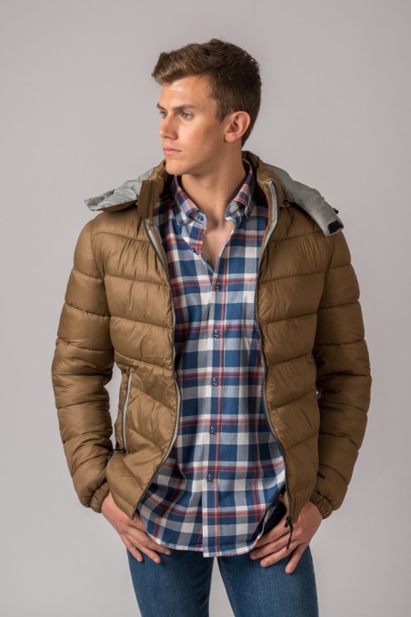 Homem com casaco acolchoado castanho e camisa xadrez azul