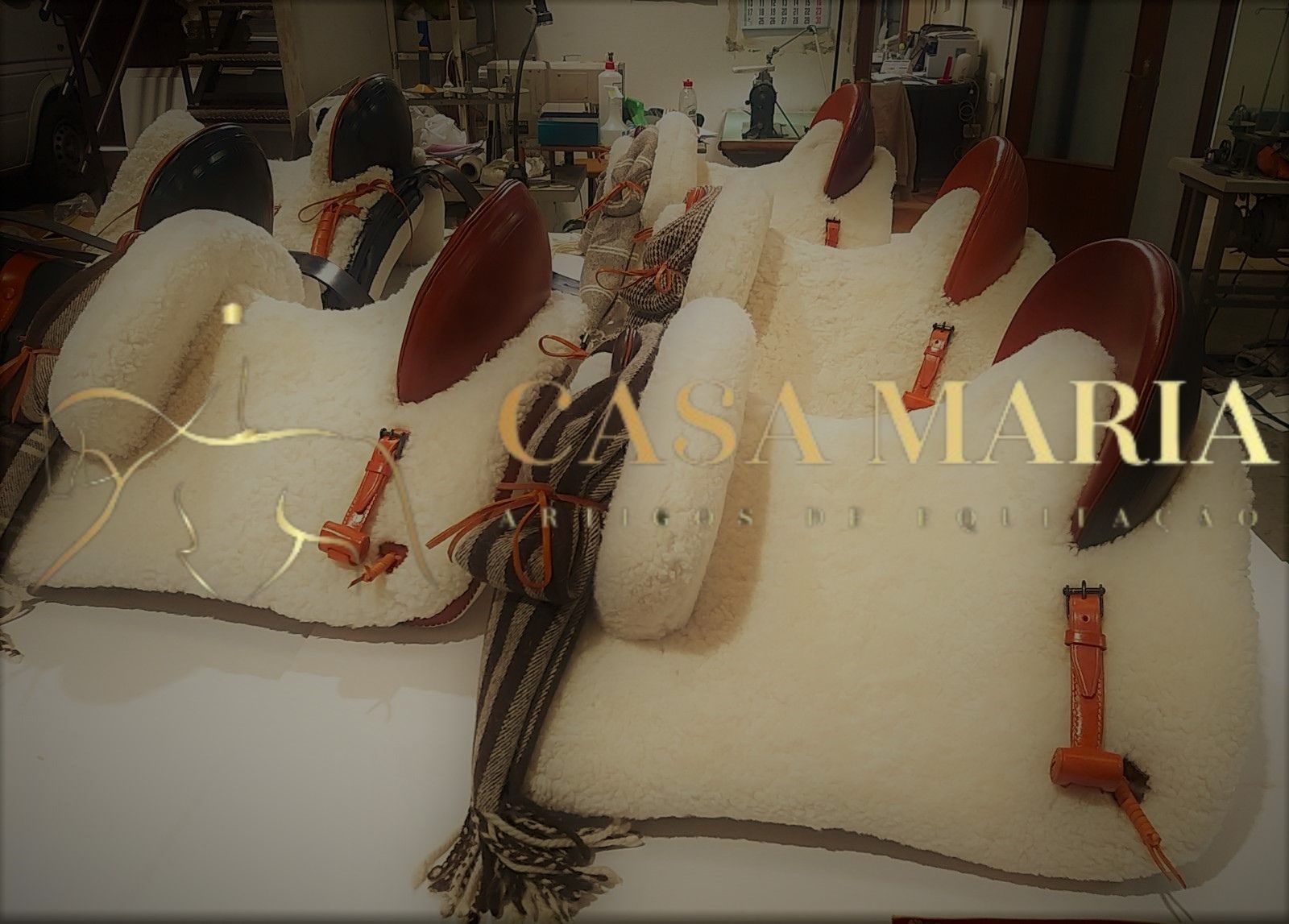 Almofadas brancas com couro castanho e tecidos rústicos em oficina com texto CASA MARIA