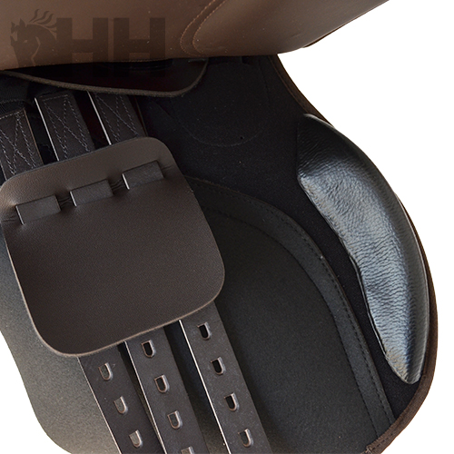 Detalhe de sela de equitação em couro castanho e tecido preto com correias de ajuste